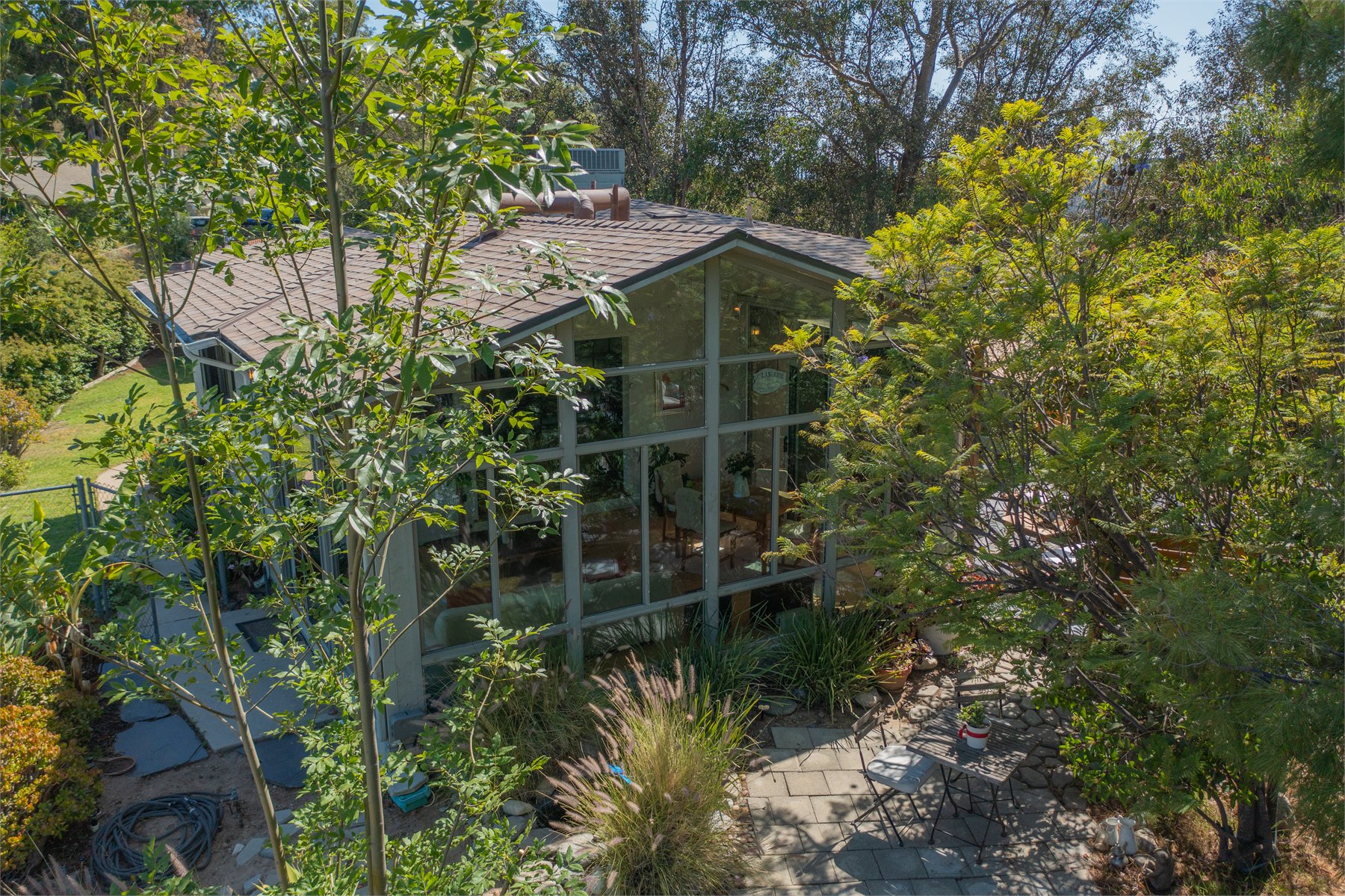 Residential drone angle through trees and hillside landscape