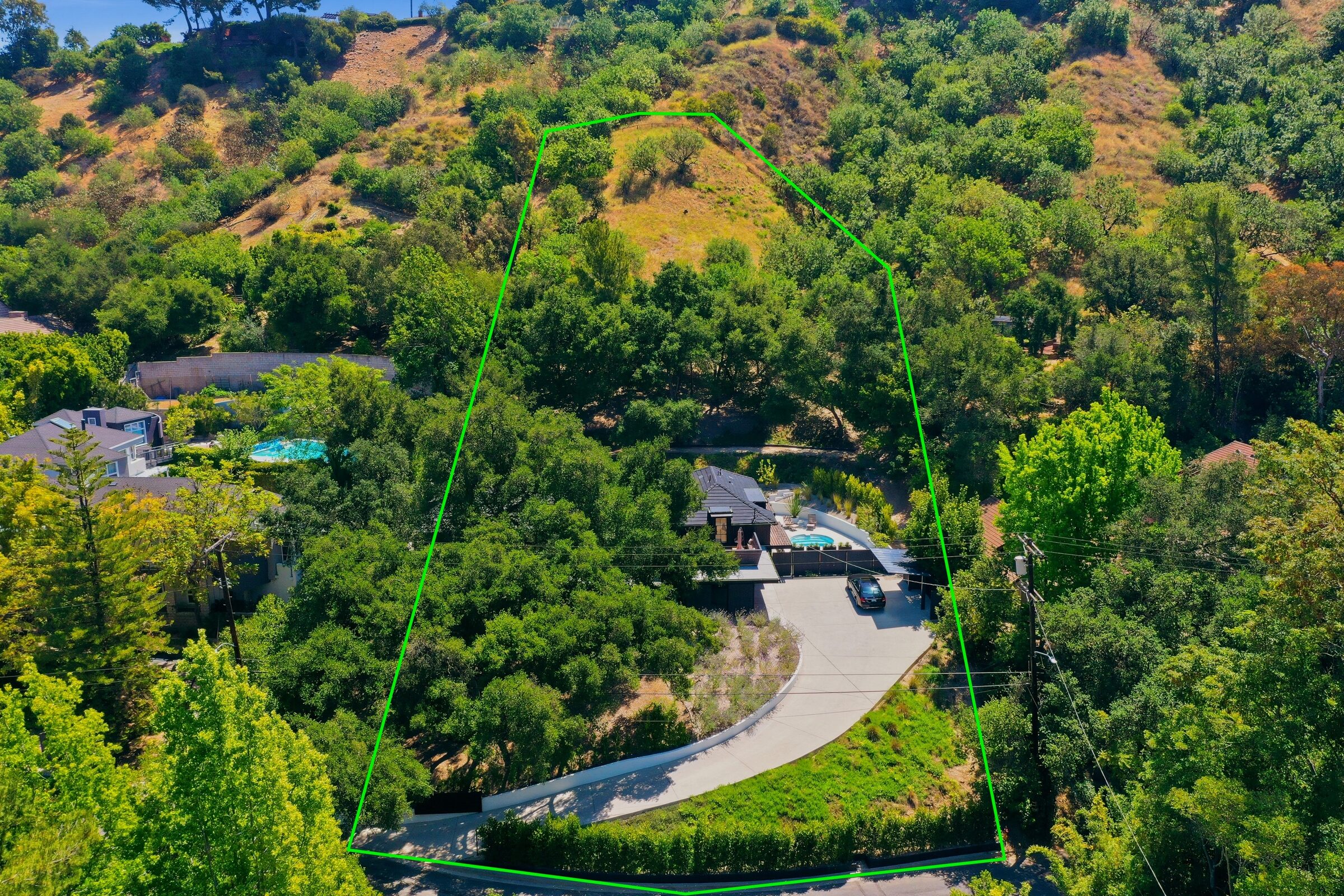 Residential drone boundary photo showing hillside parcel outline and driveway approach