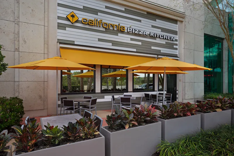 Restaurant patio with yellow umbrellas and planters