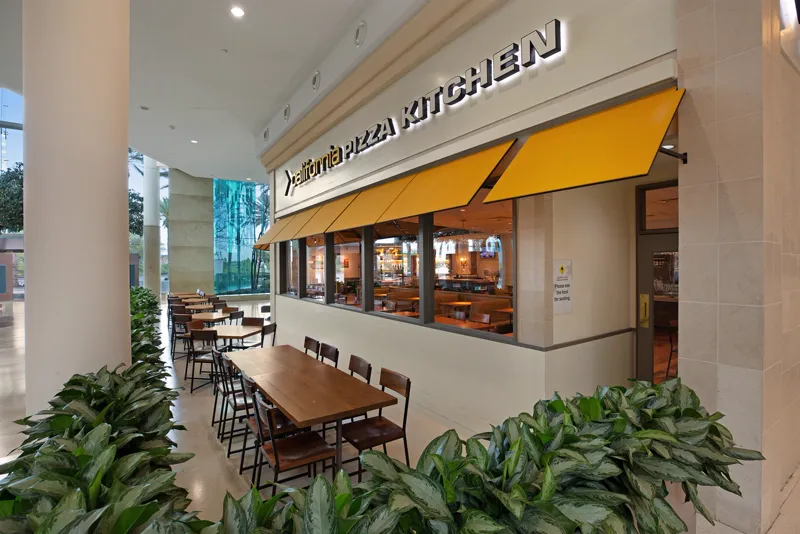 Restaurant entry framed by greenery and outdoor seating