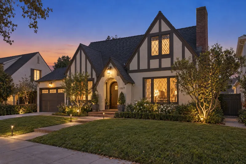 Tudor Revival home photographed at twilight from a ground-level angle