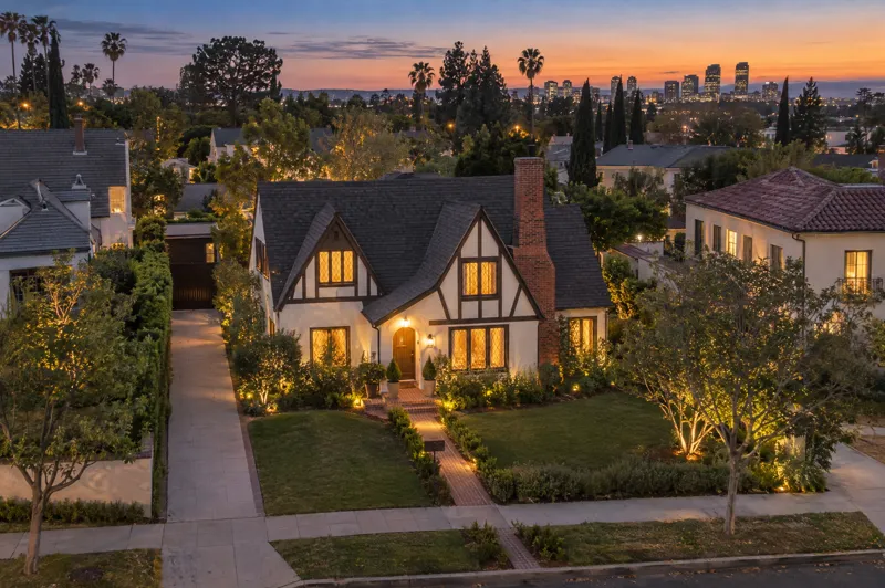 Tudor Revival home photographed at twilight from an aerial drone angle