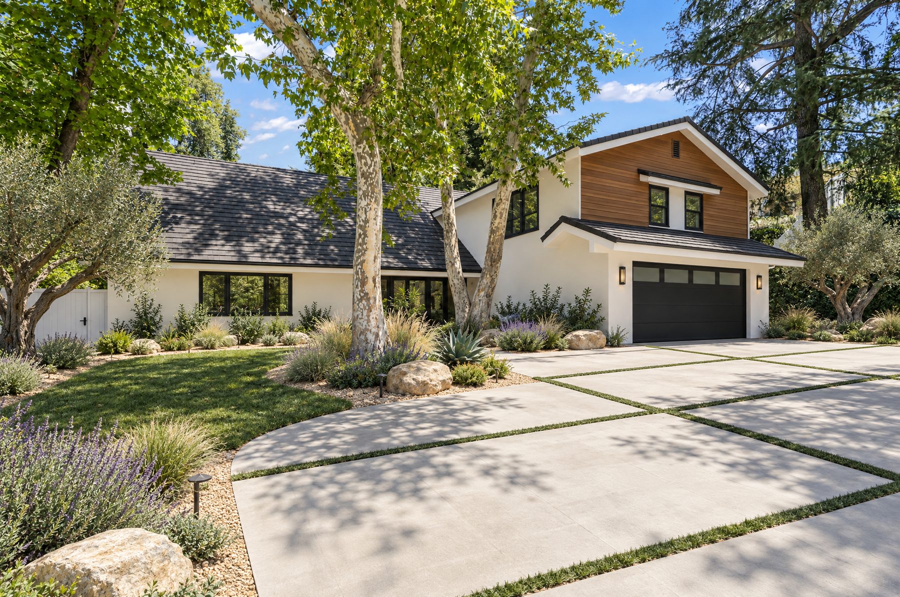 Front of a remodeled two-story home with white stucco, cedar siding, and a black garage door
