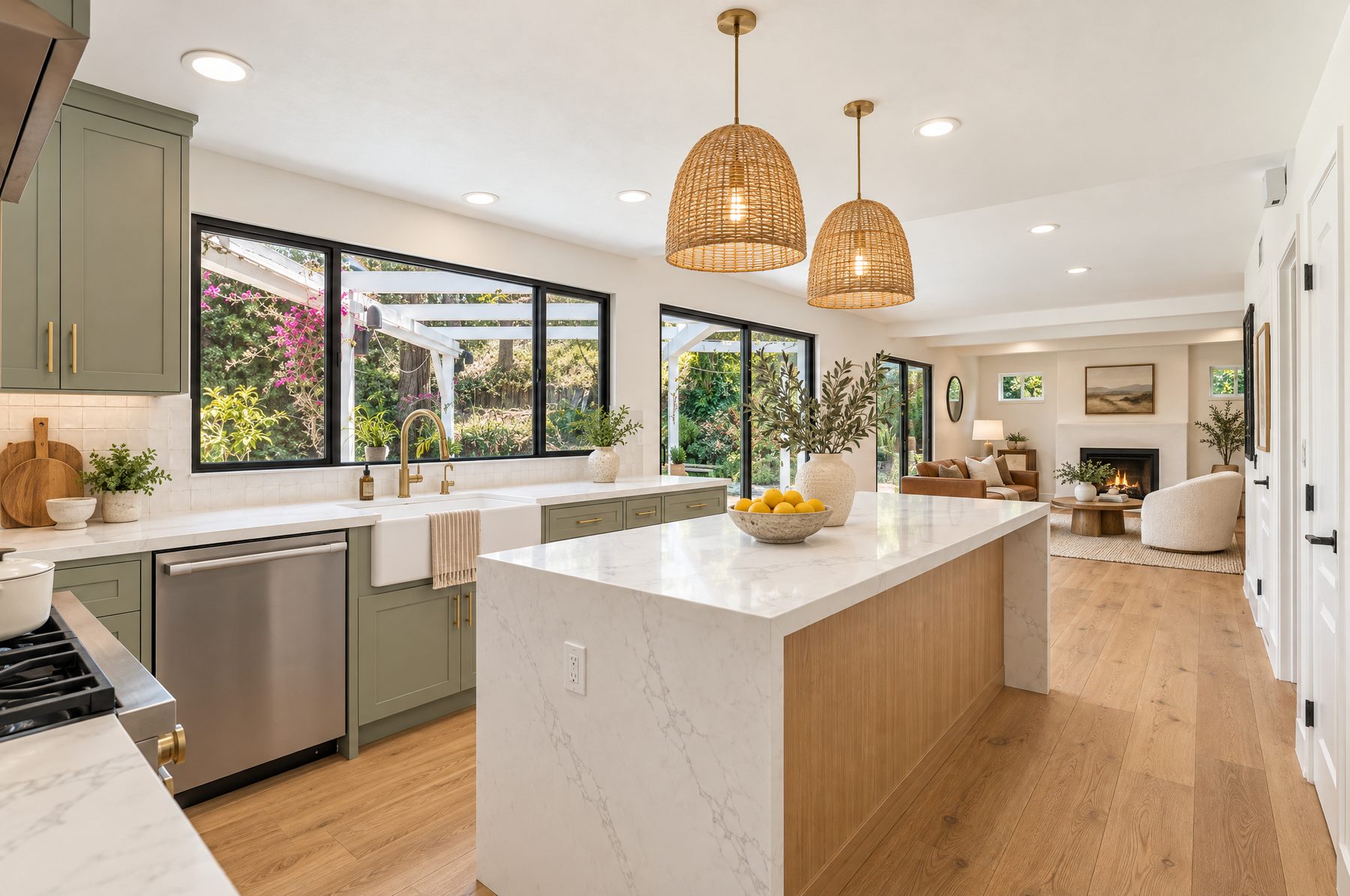 Remodeled kitchen with sage green cabinets, a white oak island, and rattan pendants